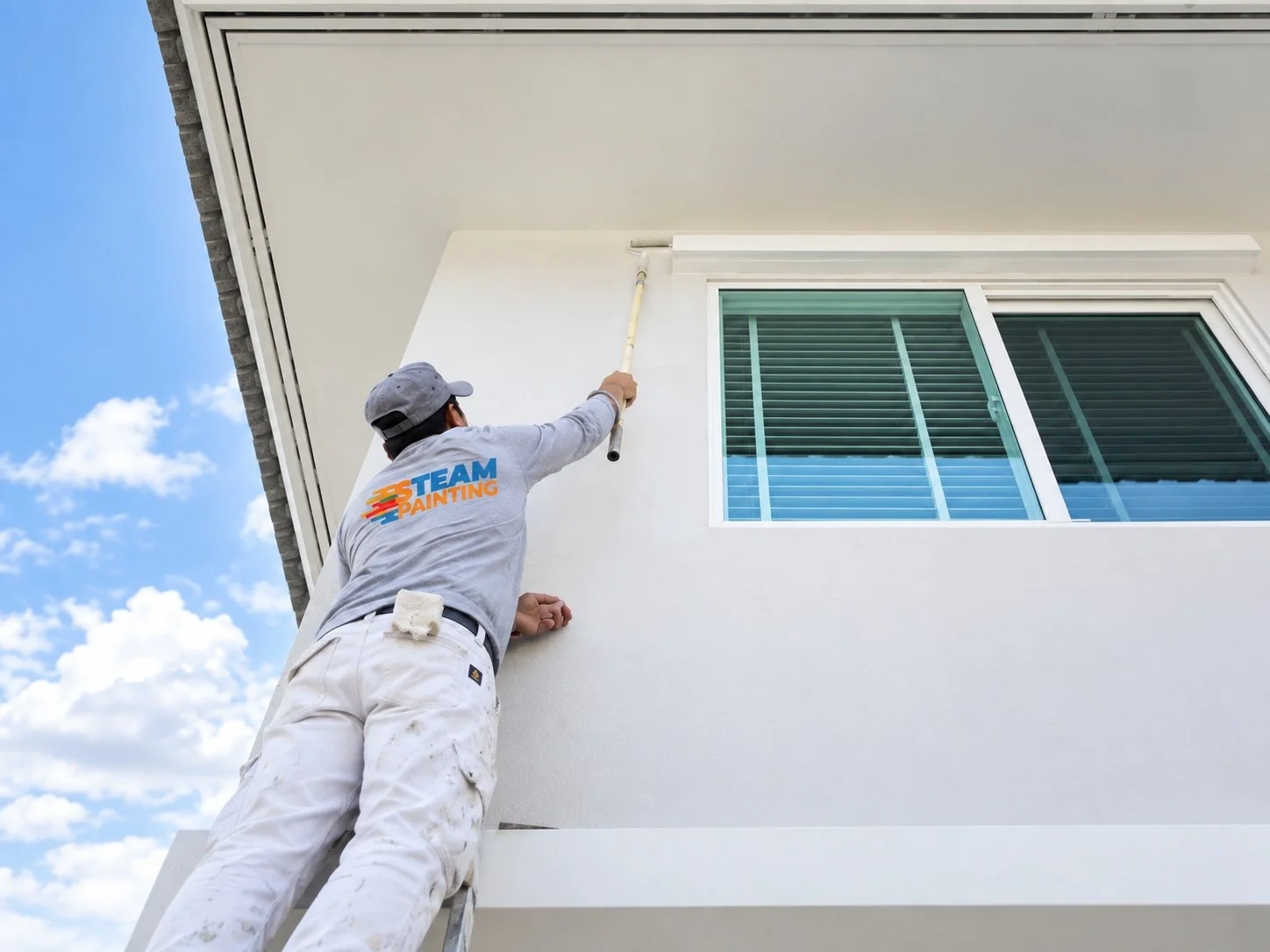 S-Team Painting professional working on an exterior home painting project